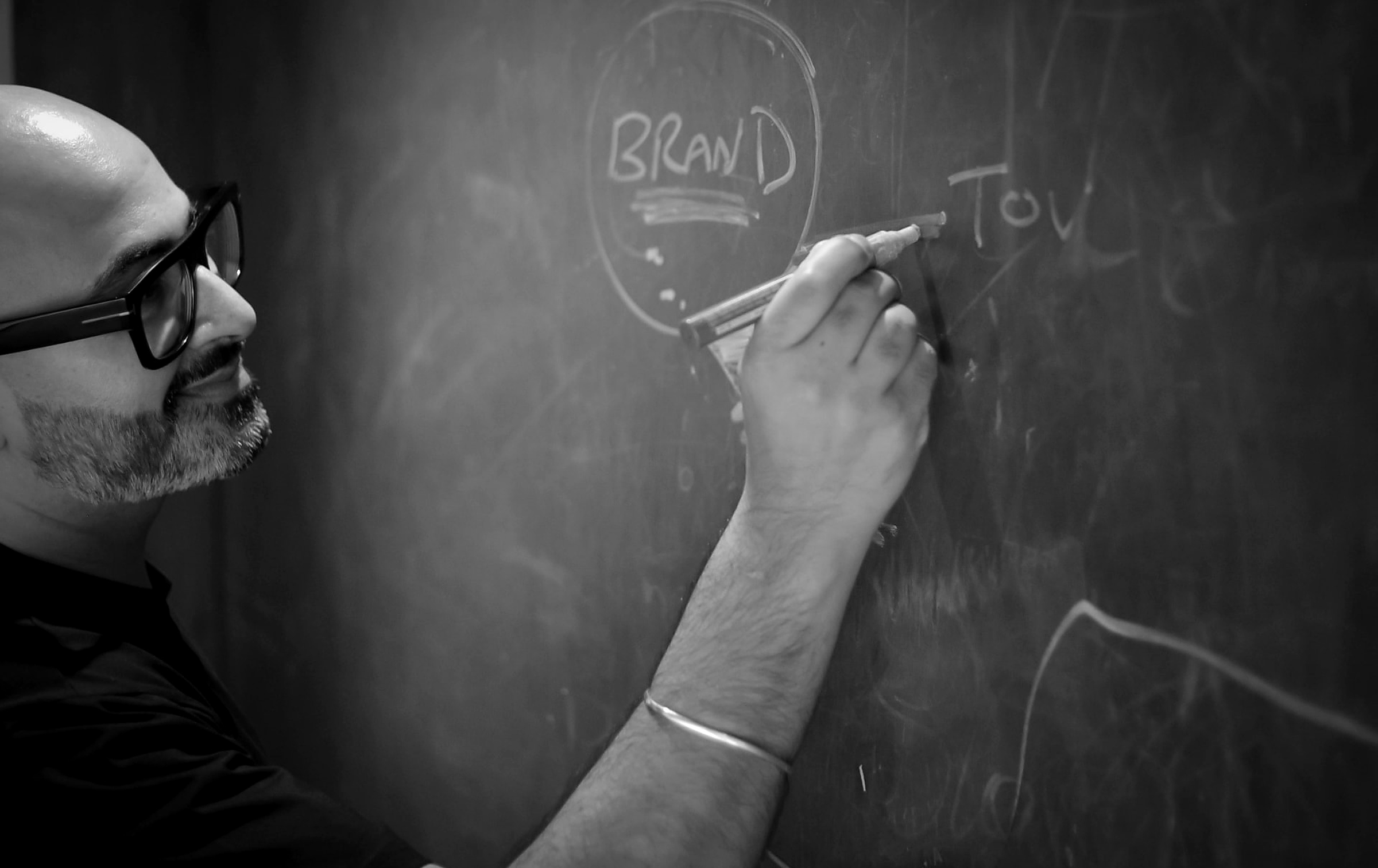 Avy Pruthi mapping brand strategy on a chalkboard during a working session