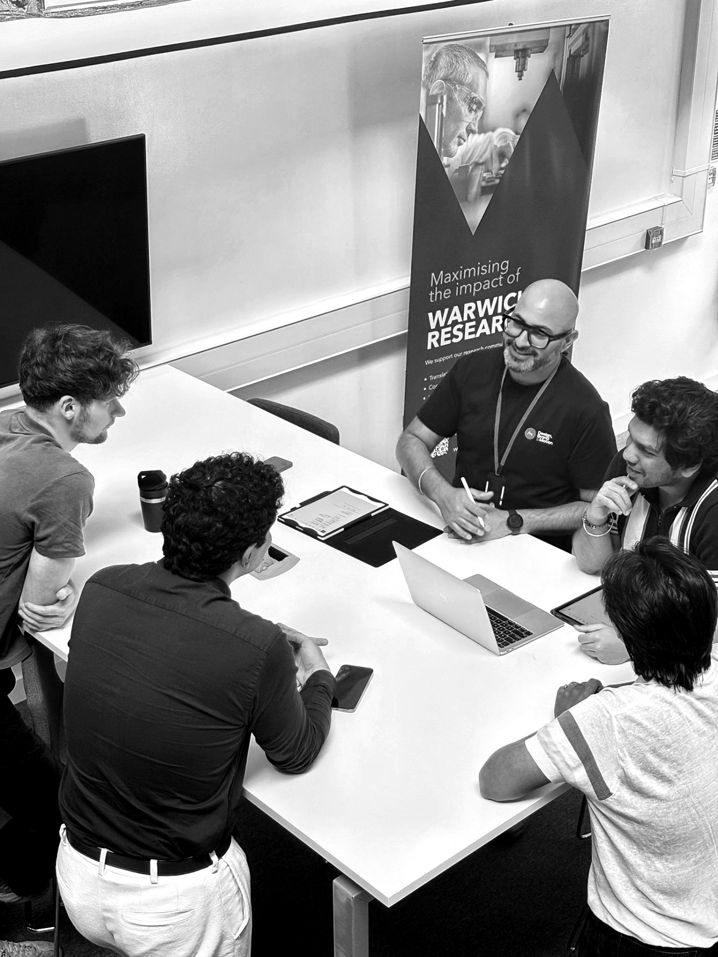Avy Pruthi in a working session with colleagues around a project table